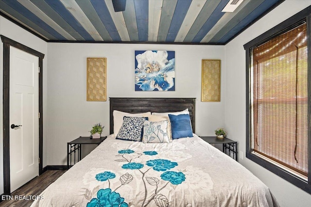 bedroom featuring dark hardwood / wood-style flooring and wooden ceiling