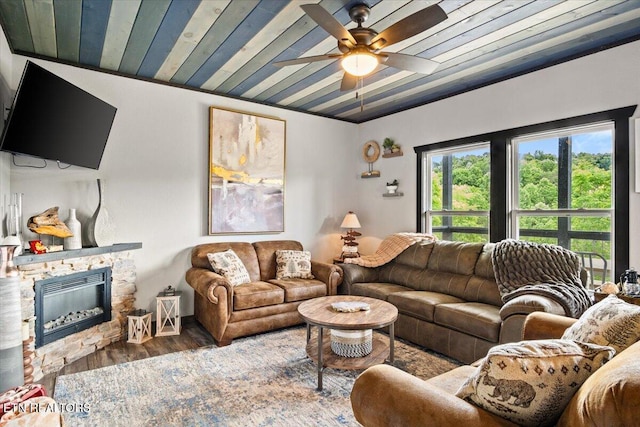 living room featuring wood ceiling, hardwood / wood-style flooring, a fireplace, and ceiling fan