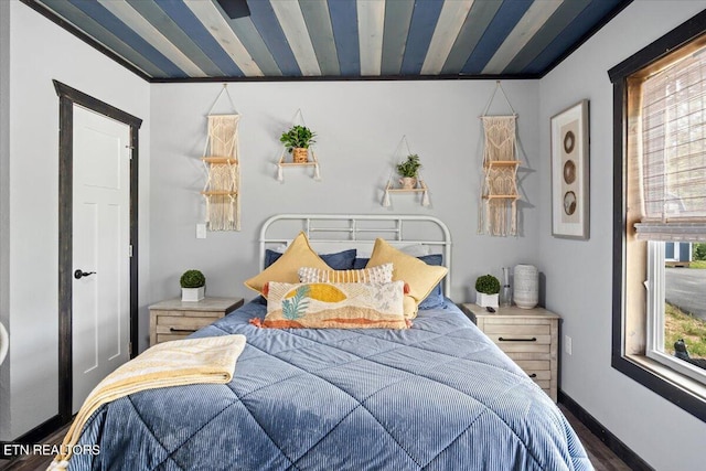 bedroom with dark hardwood / wood-style flooring and multiple windows