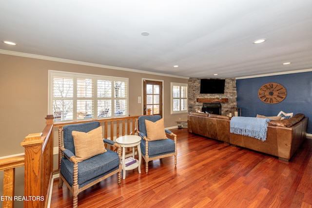 living room featuring ornamental molding, hardwood / wood-style floors, and a fireplace