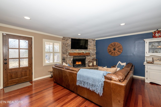 living room featuring dark hardwood / wood-style flooring, a stone fireplace, and ornamental molding