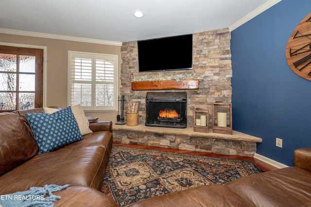 living room with hardwood / wood-style floors, crown molding, and a stone fireplace