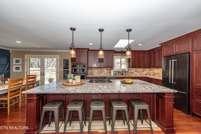 kitchen with pendant lighting, a center island, high end fridge, and sink