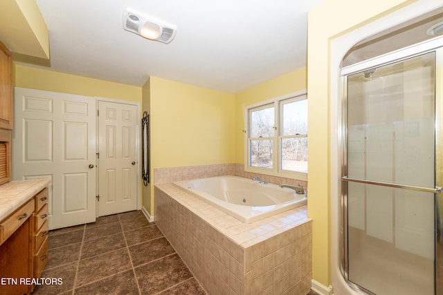 bathroom featuring vanity and independent shower and bath