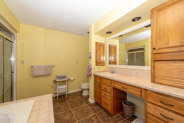 bathroom featuring vanity, toilet, walk in shower, and decorative backsplash