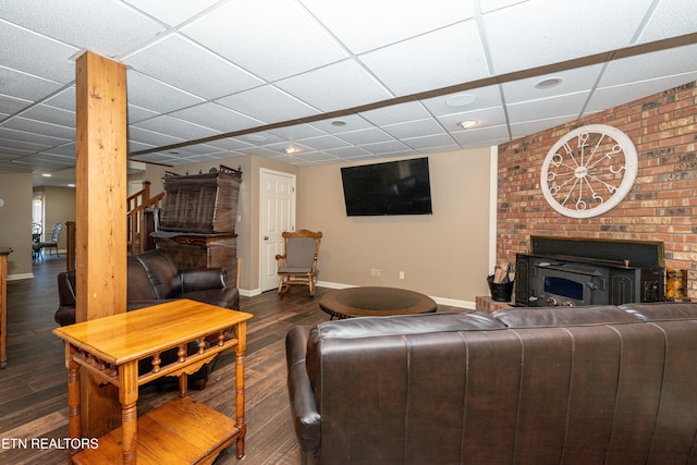 living room with a paneled ceiling and dark hardwood / wood-style floors