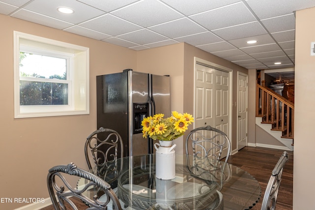 dining room with a paneled ceiling and dark hardwood / wood-style floors