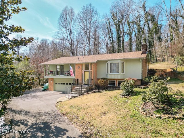 raised ranch featuring a garage and a front lawn