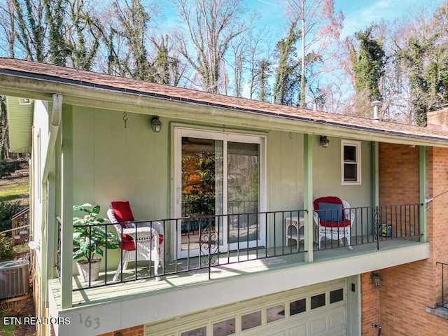 back of house featuring a garage, central AC, and a balcony