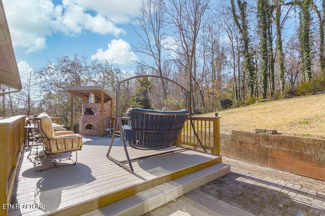 wooden deck with an outdoor brick fireplace