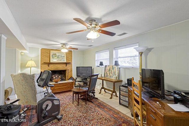 office space with a textured ceiling, a brick fireplace, and light tile patterned floors