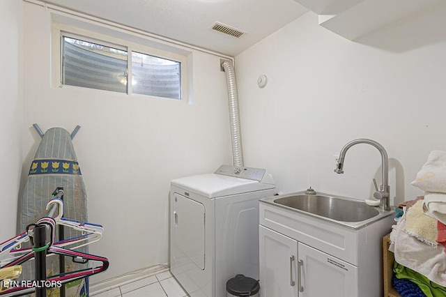 laundry area featuring cabinets, sink, washer and dryer, and light tile patterned floors