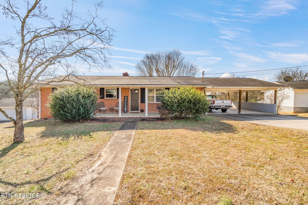 ranch-style house featuring a front lawn, a carport, and a porch