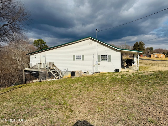 back of property with central AC and a lawn