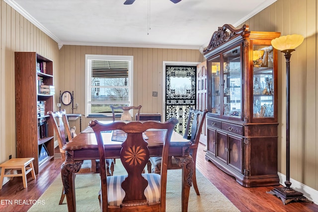 dining room featuring ornamental molding, wood finished floors, a ceiling fan, and baseboards