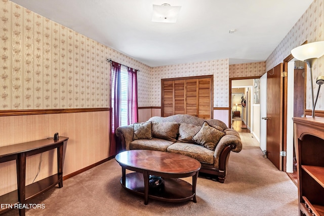 carpeted living area featuring wainscoting and wallpapered walls