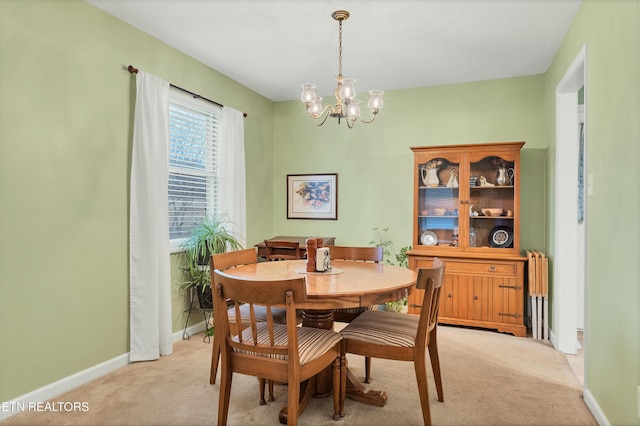 carpeted dining room with an inviting chandelier