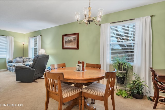 dining room with an inviting chandelier and light colored carpet