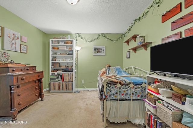 bedroom featuring light carpet and a textured ceiling