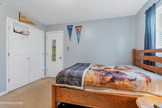 bedroom featuring a closet, carpet, and a textured ceiling