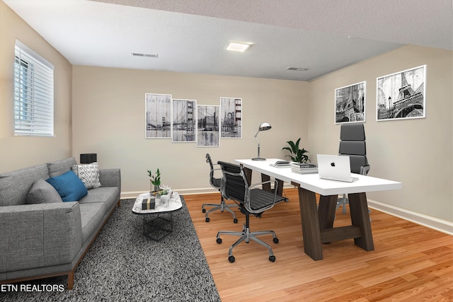 home office with hardwood / wood-style flooring and a textured ceiling