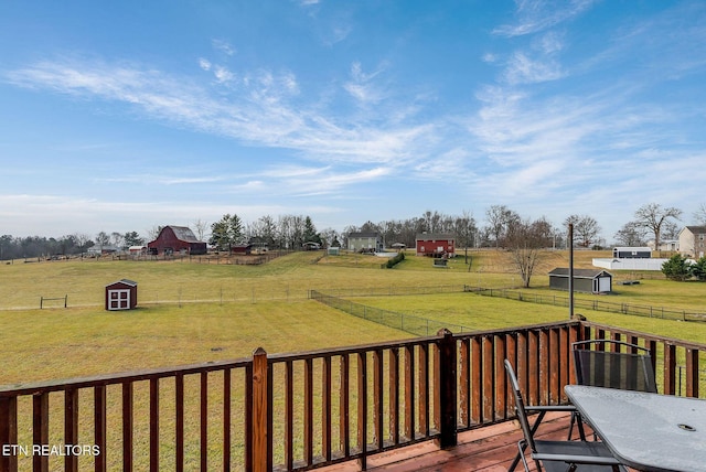 deck featuring a storage shed, a yard, and a rural view