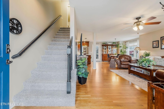 staircase featuring hardwood / wood-style floors and ceiling fan