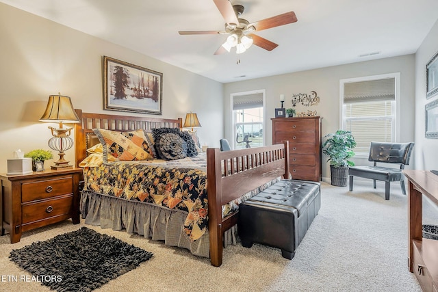 bedroom with ceiling fan and light carpet