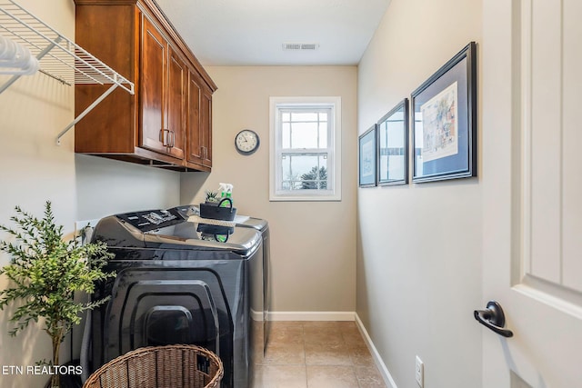 washroom with cabinets, washing machine and clothes dryer, and light tile patterned flooring