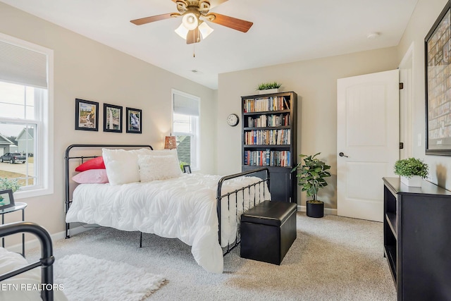 bedroom with multiple windows, light colored carpet, and ceiling fan