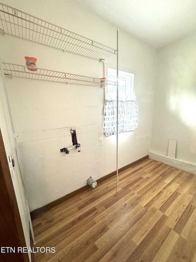 laundry area with wood-type flooring