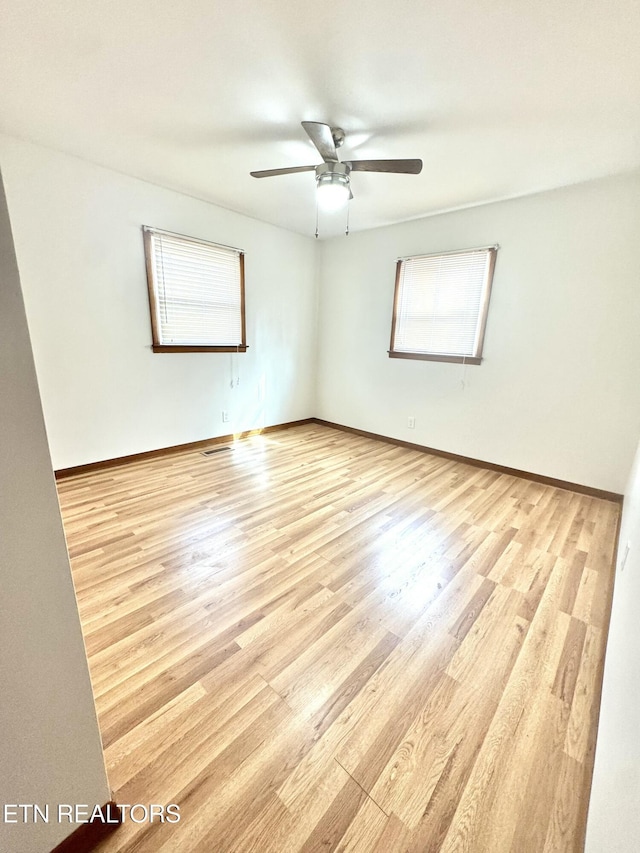 spare room with ceiling fan and light wood-type flooring