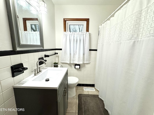 bathroom featuring tile walls, vanity, toilet, tile patterned floors, and a shower with curtain