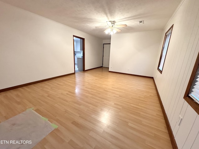 spare room with ceiling fan, light hardwood / wood-style flooring, and a textured ceiling