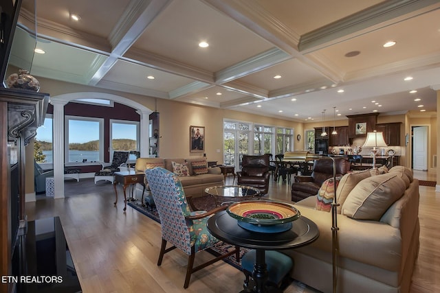 living room featuring ornate columns, plenty of natural light, coffered ceiling, and beamed ceiling