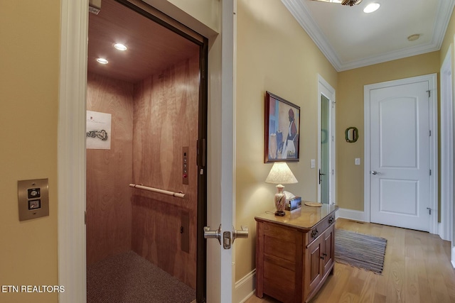 doorway to outside with elevator, ornamental molding, and light hardwood / wood-style flooring