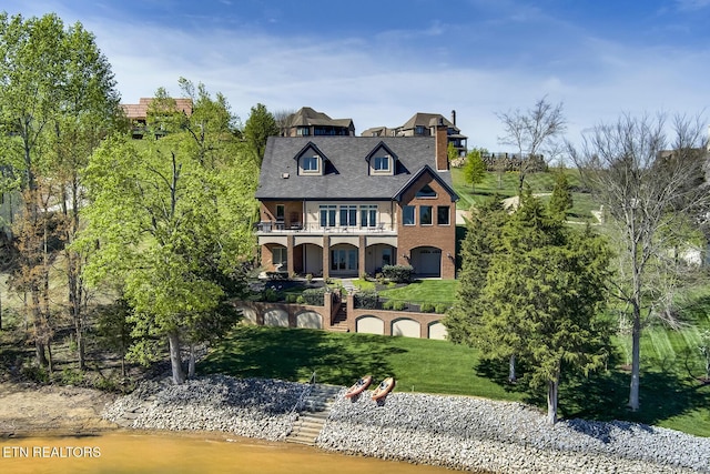 view of front of property featuring a balcony and a front lawn