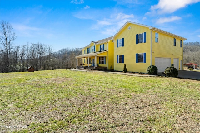 exterior space with a garage, covered porch, aphalt driveway, and a lawn