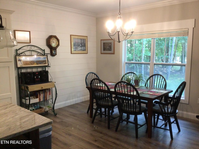 dining area featuring dark wood-type flooring, ornamental molding, and a chandelier