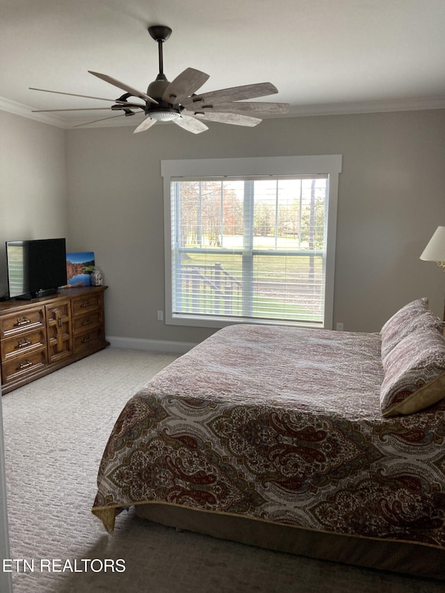 carpeted bedroom with ceiling fan and ornamental molding