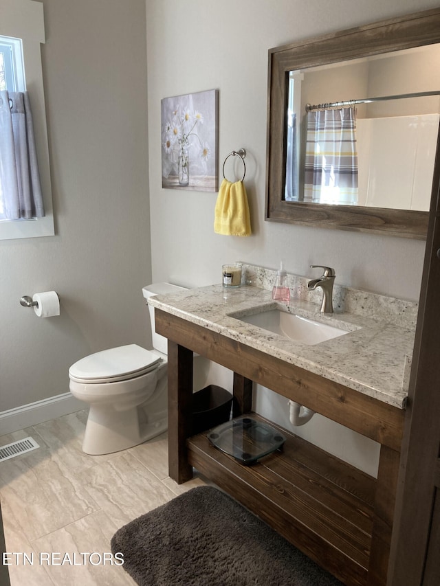 bathroom with sink, curtained shower, and toilet