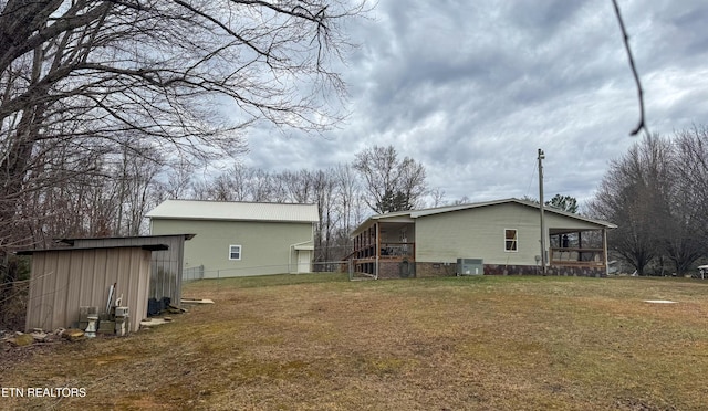 rear view of house featuring a yard and central AC