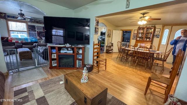 living room with hardwood / wood-style flooring, ceiling fan, and lofted ceiling