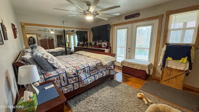 bedroom featuring ceiling fan, access to exterior, hardwood / wood-style floors, french doors, and a closet