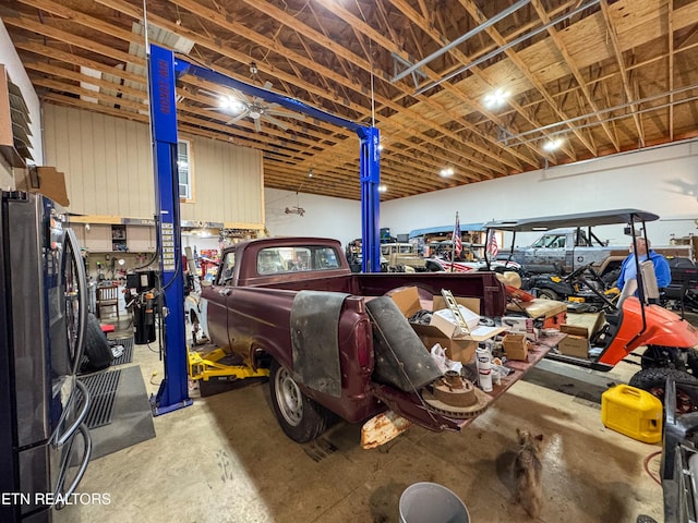 garage featuring stainless steel refrigerator and a workshop area