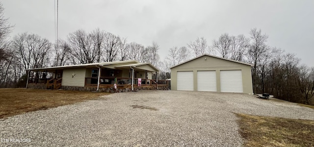 view of front facade with an outbuilding, a garage, and covered porch