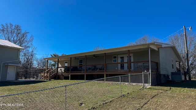 back of house featuring cooling unit, covered porch, and a lawn