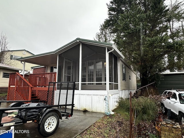 view of side of property with a deck and a sunroom