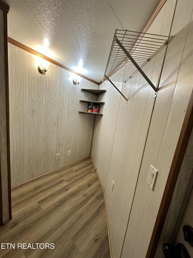 basement with hardwood / wood-style floors, a textured ceiling, and wood walls