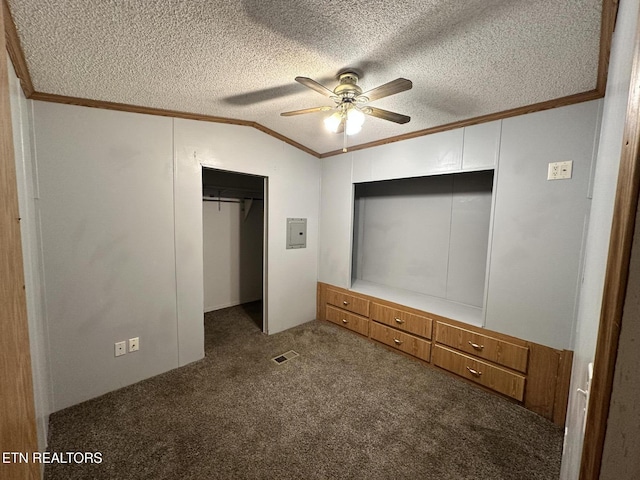 unfurnished bedroom featuring ornamental molding, vaulted ceiling, carpet, and a textured ceiling